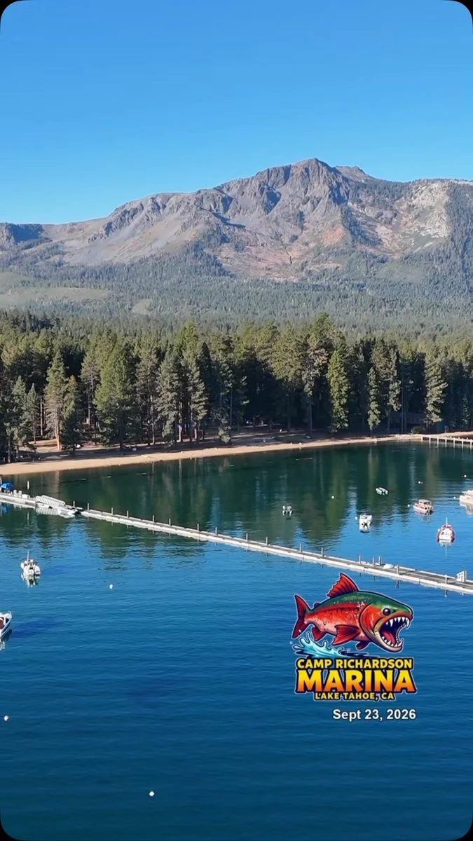 Sierra mountains, forest and boats reflected in blue water at Camp Richardson Marina.