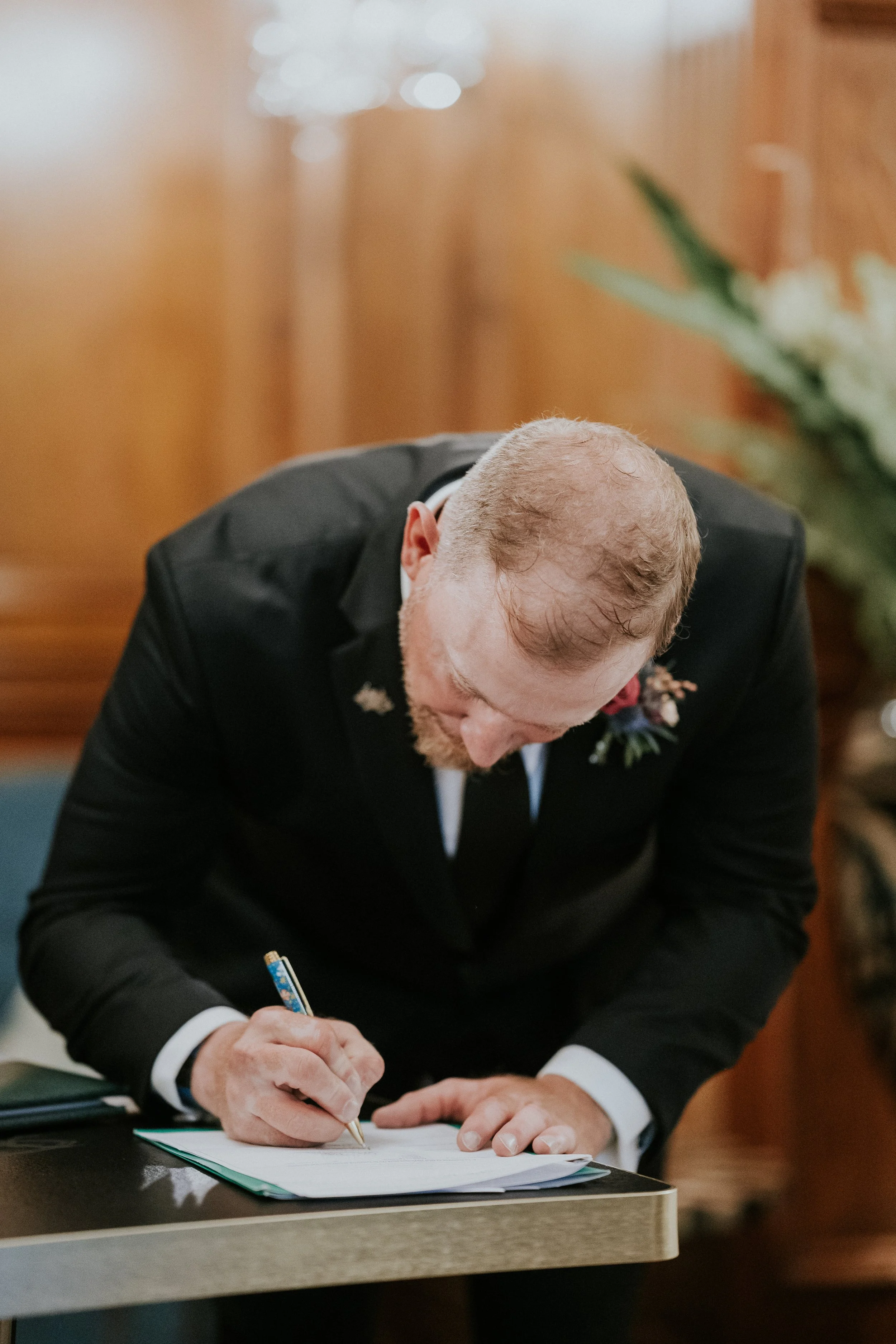Groom signing the legal marriage paperwork at an Ireland elopement ceremony