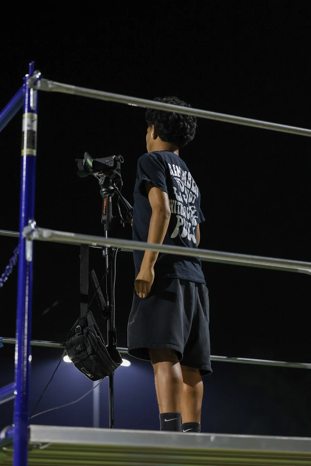 HTP videographer operating a camera on an elevated platform at night