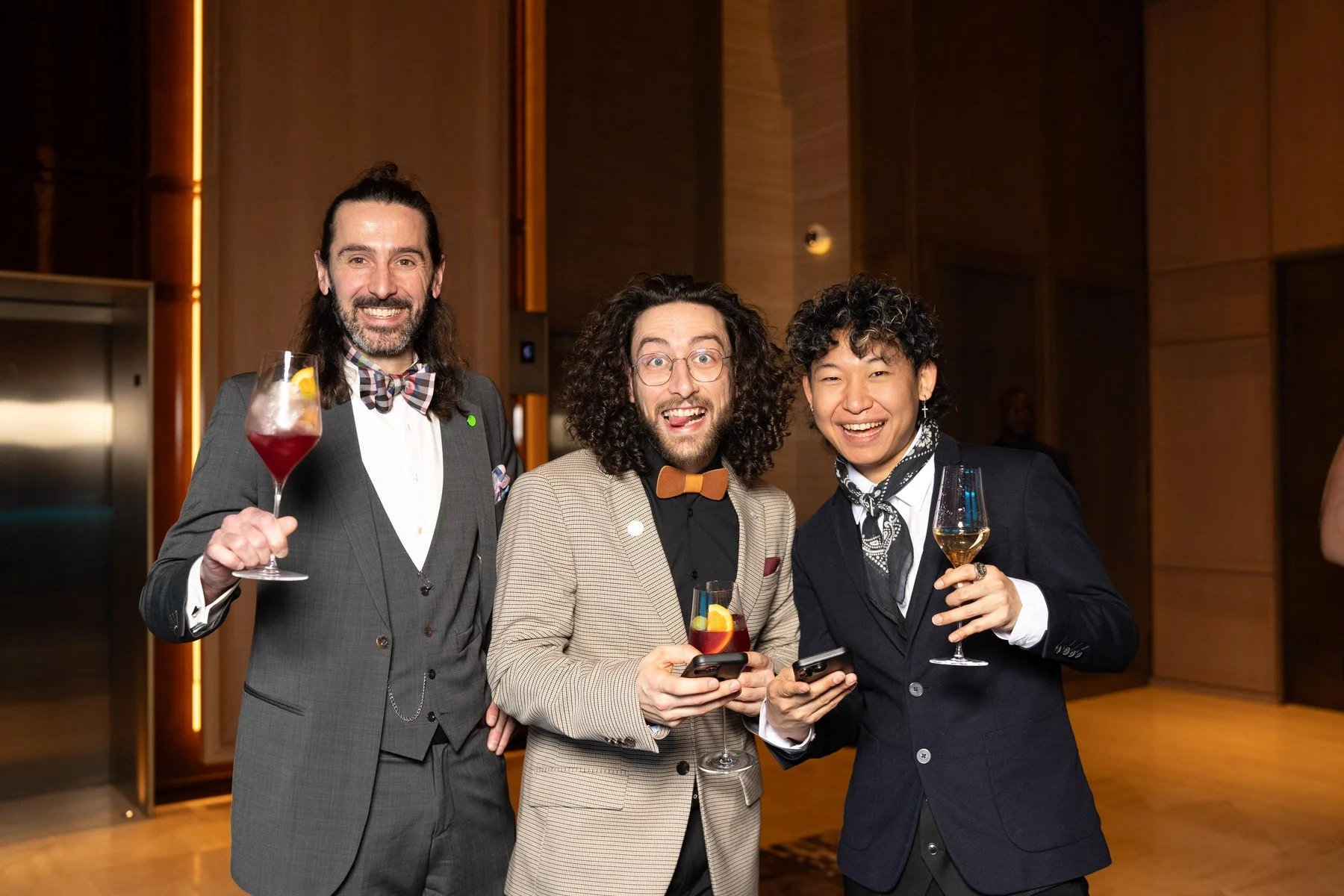 Three finalists celebrating with cocktails after the World Young Chef, Waiter & Mixologist Championship