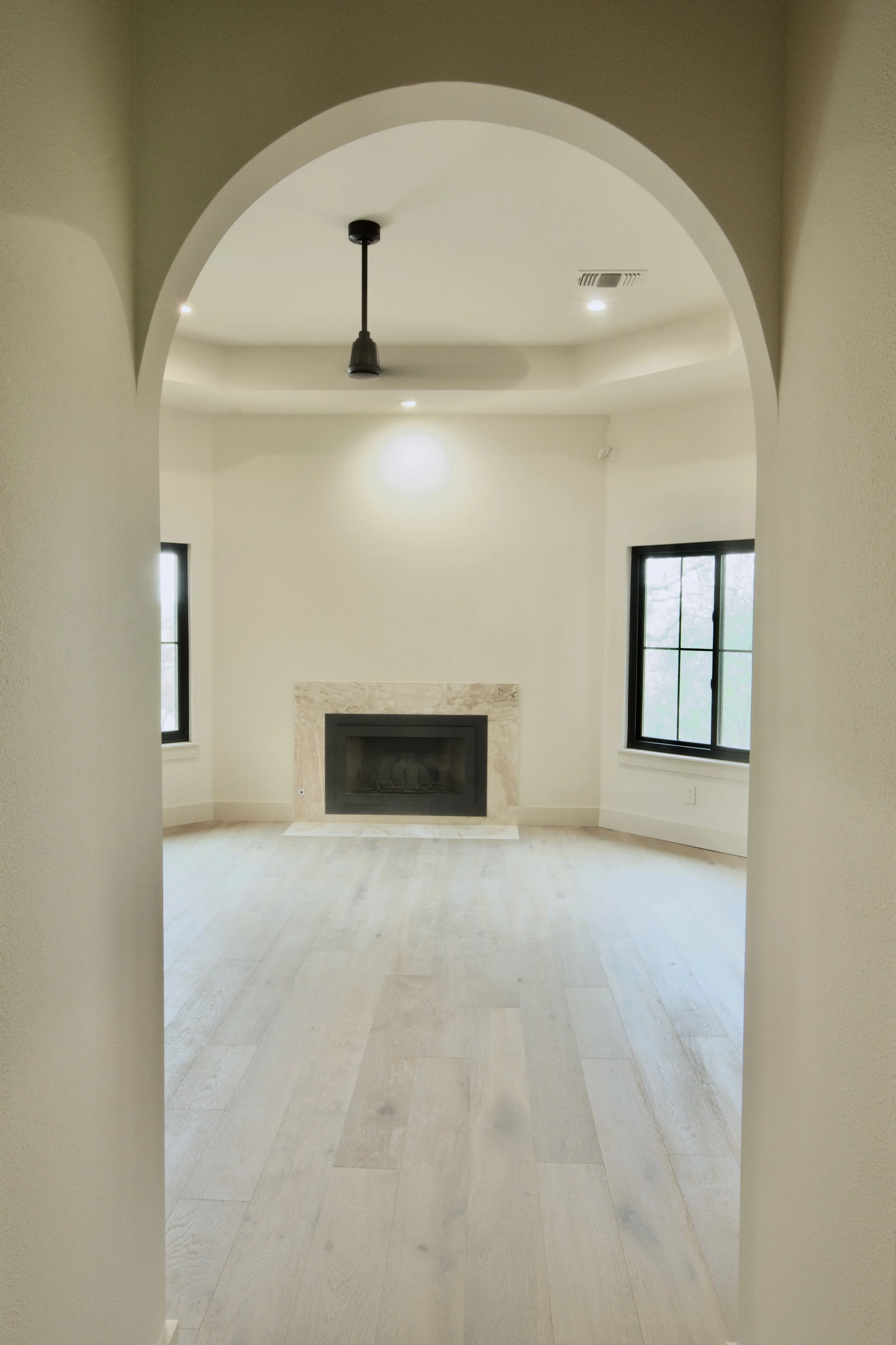 Primary bedroom with redesigned fireplace, archway, and Surry Hill engineered hardwood