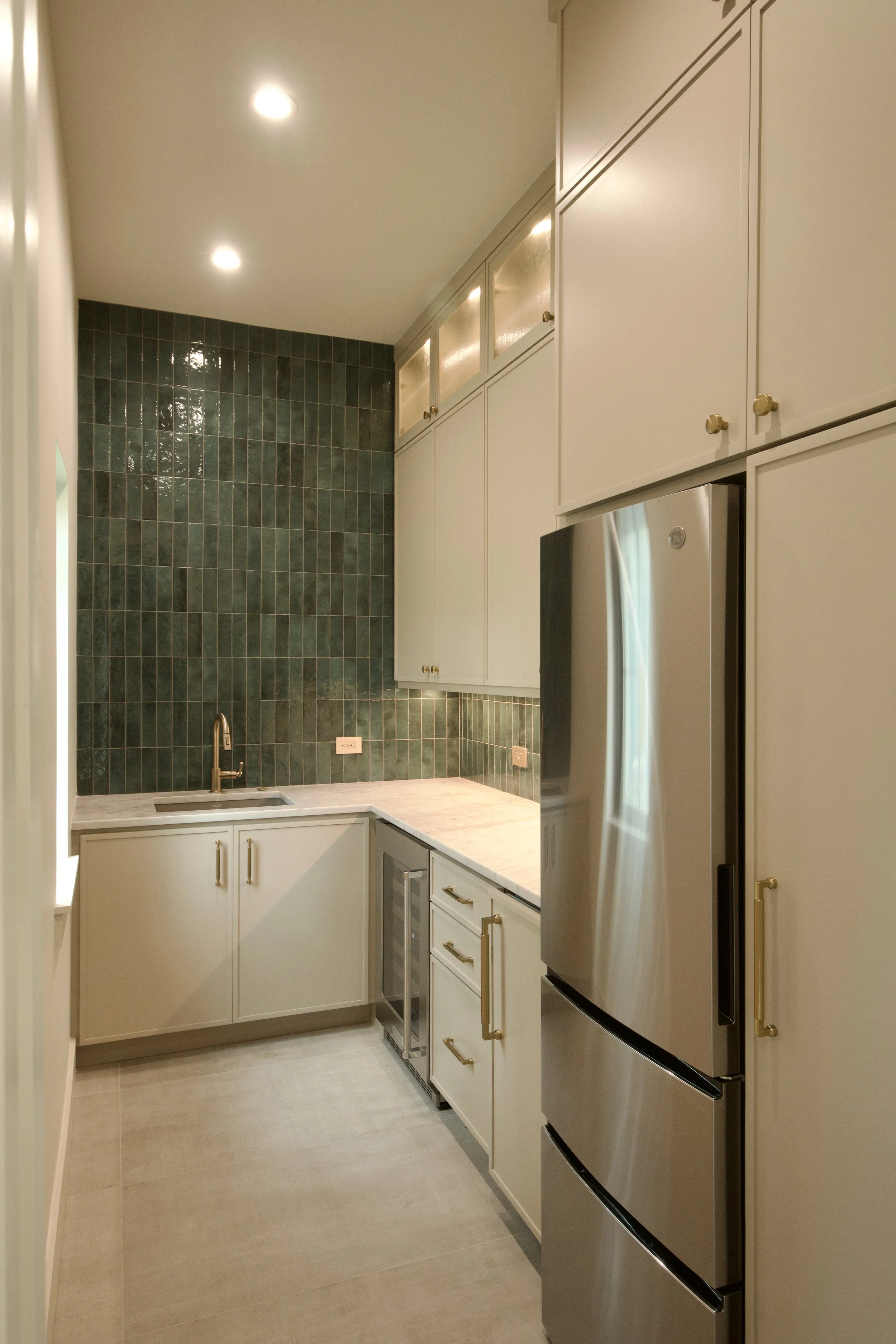 Butler's pantry with green tile, secondary refrigerator, prep sink, and wine area