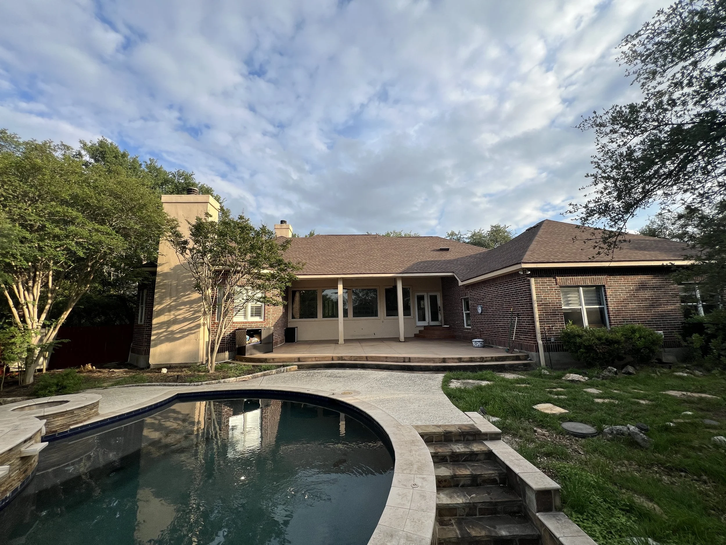 Original red brick rear elevation with covered patio and pool, before the San Marcos renovation