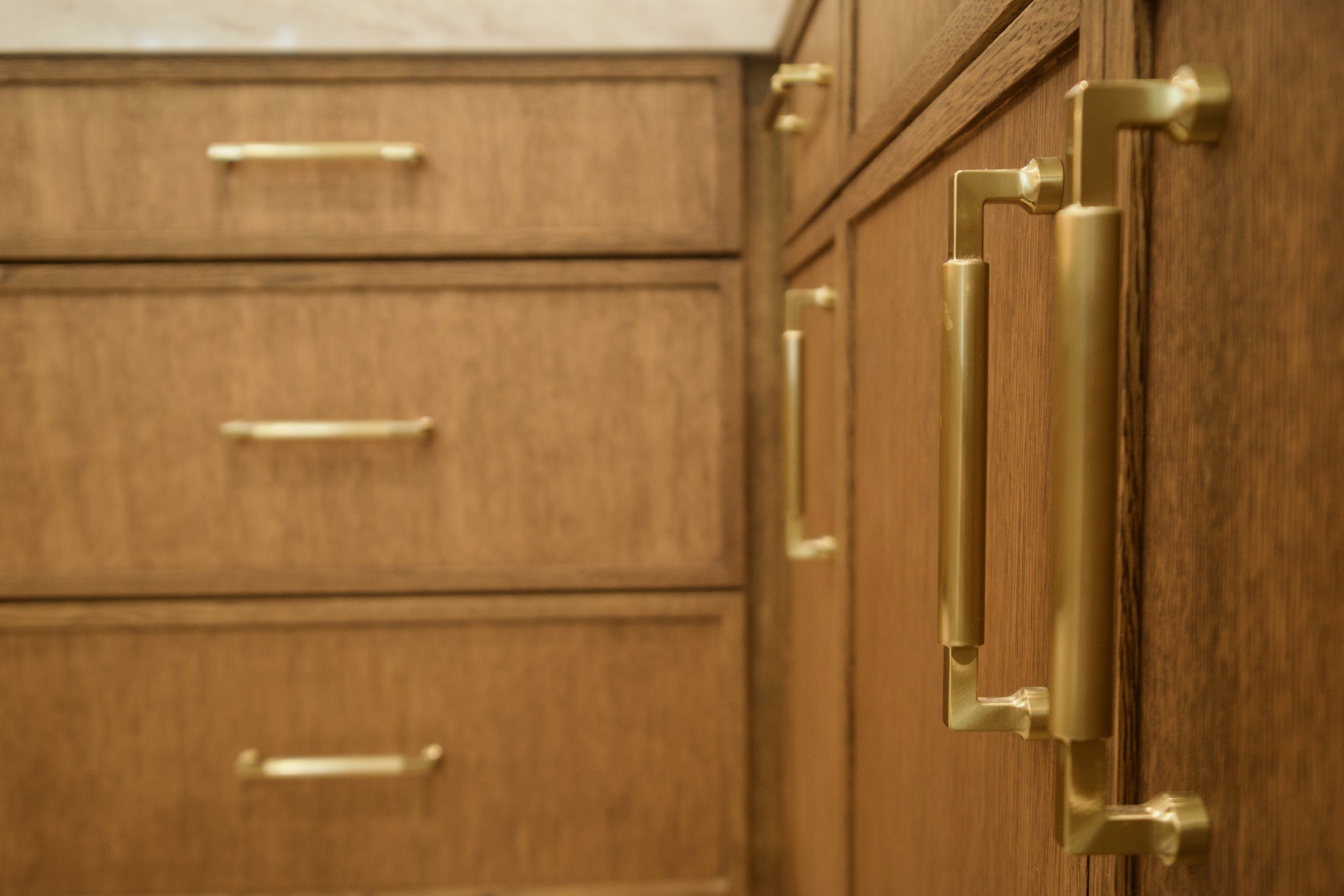 Detail of brass pulls and white oak grain on the kitchen island