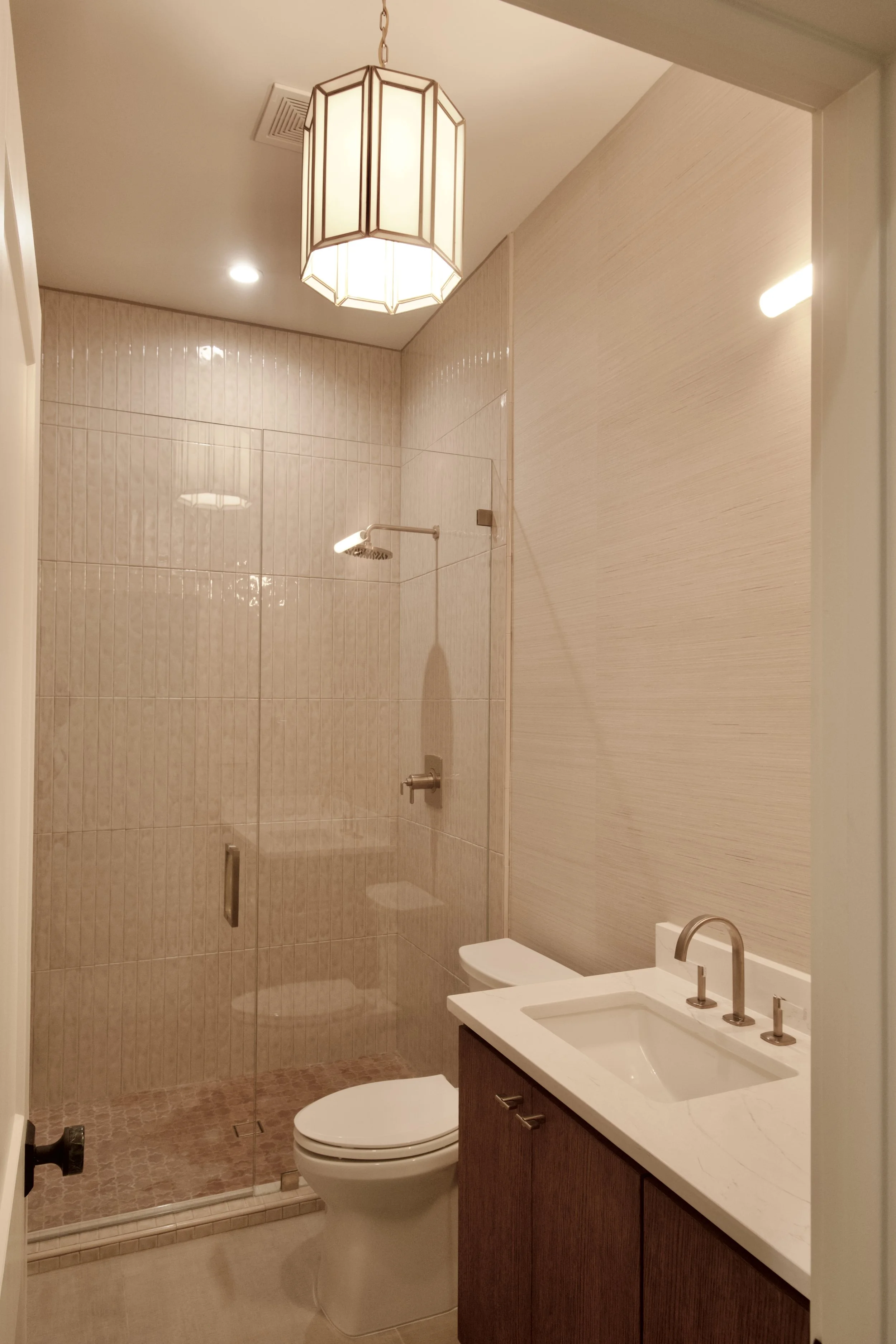 Powder bath with custom floating wood vanity, lantern fixture, and glass shower
