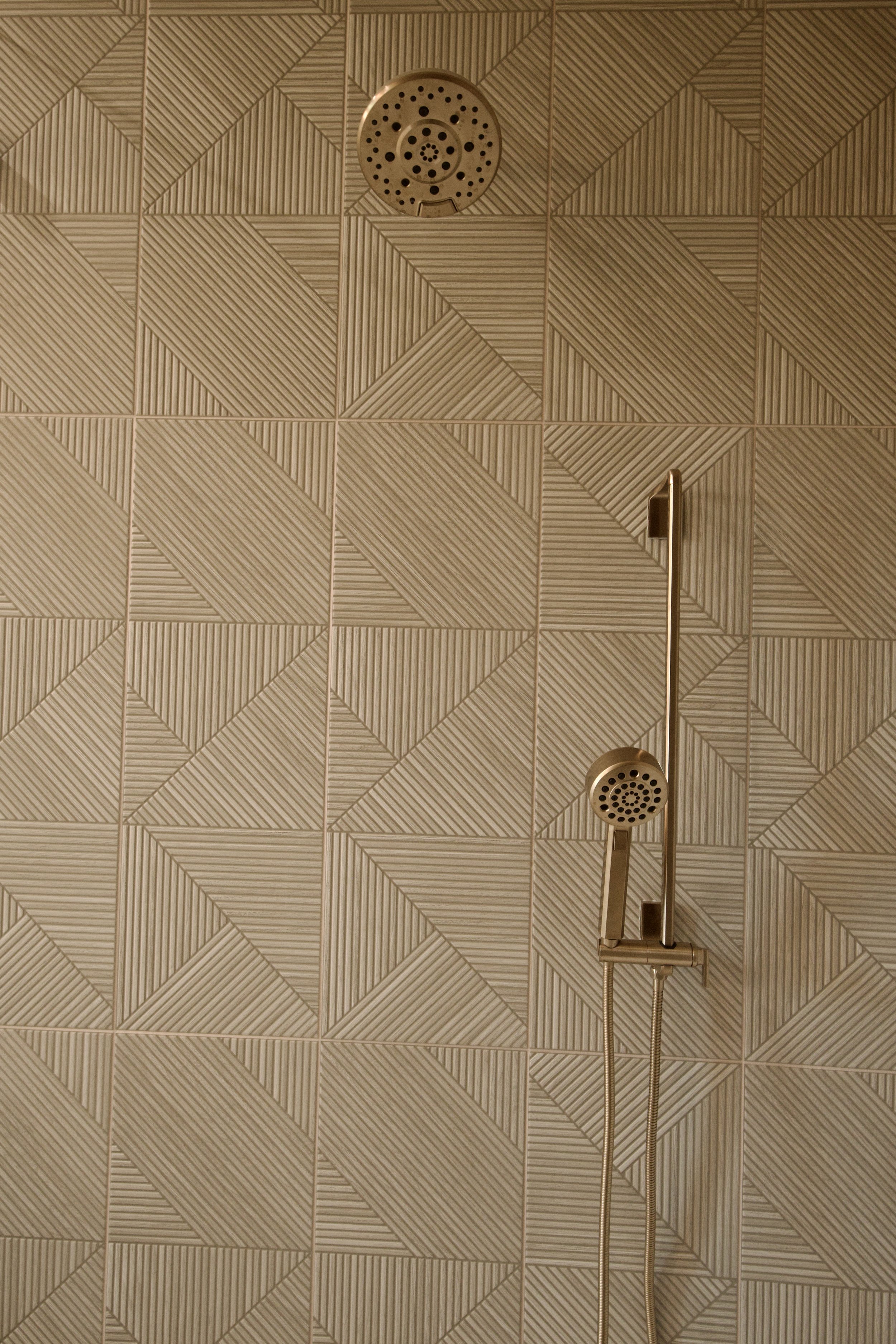 Spa-inspired primary bathroom dual-entry shower with geometric tile and brushed fixtures