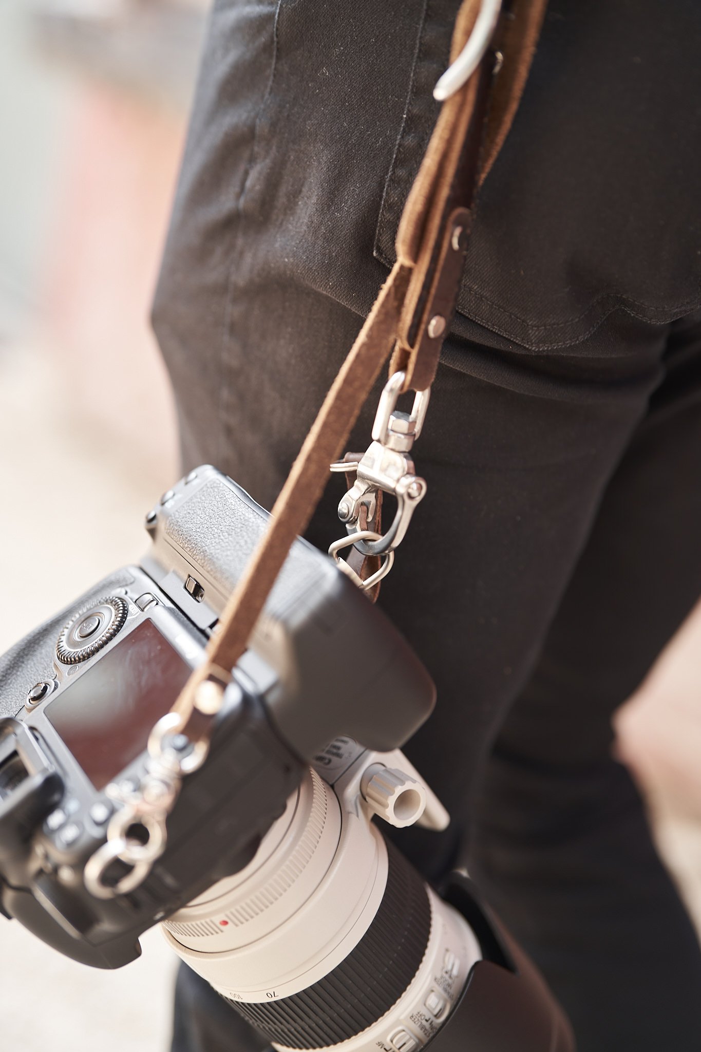 An Ikonic Leather Works strap clipped to a camera, close up