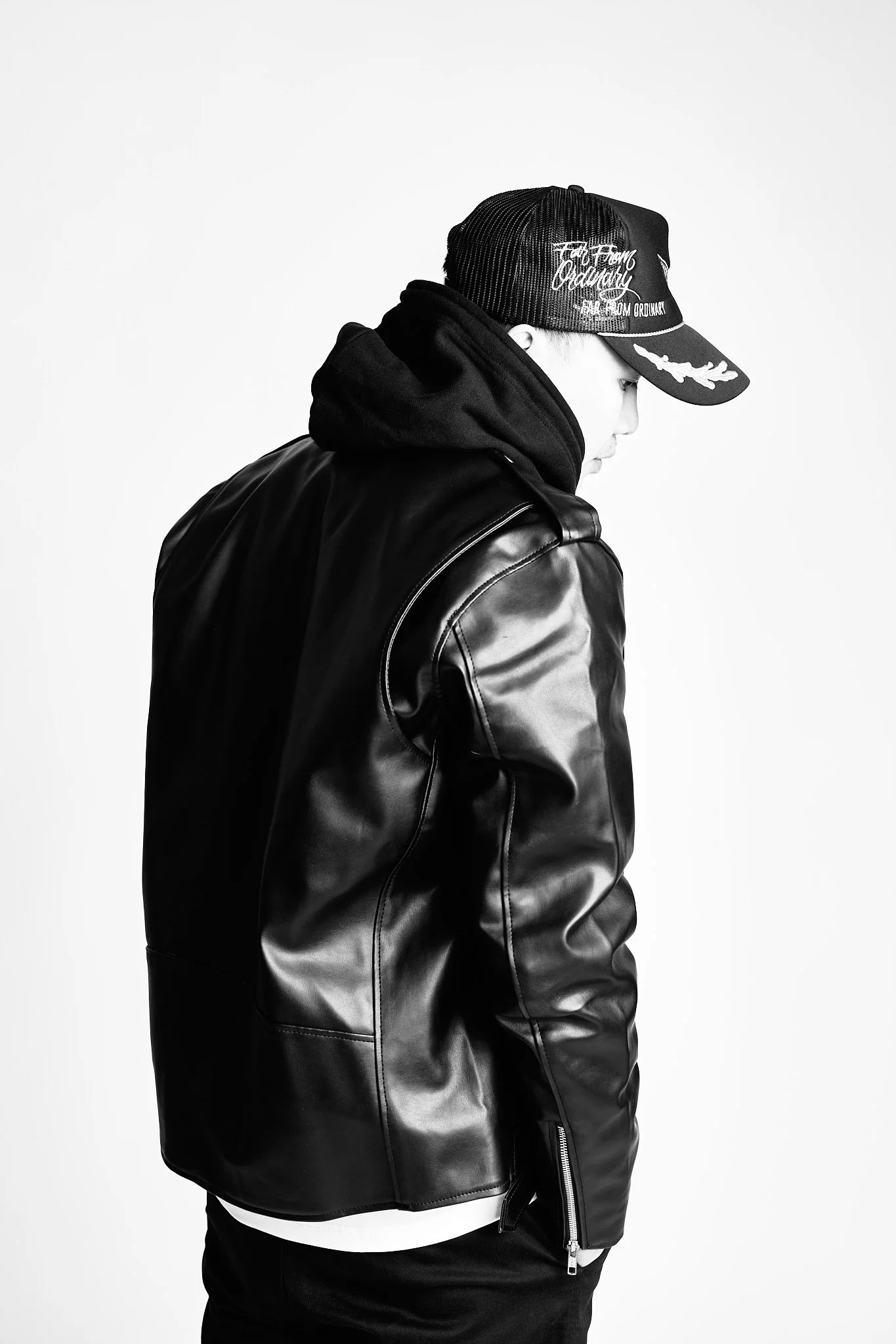 Adrian turned away in a Far From Ordinary cap and leather jacket, black and white