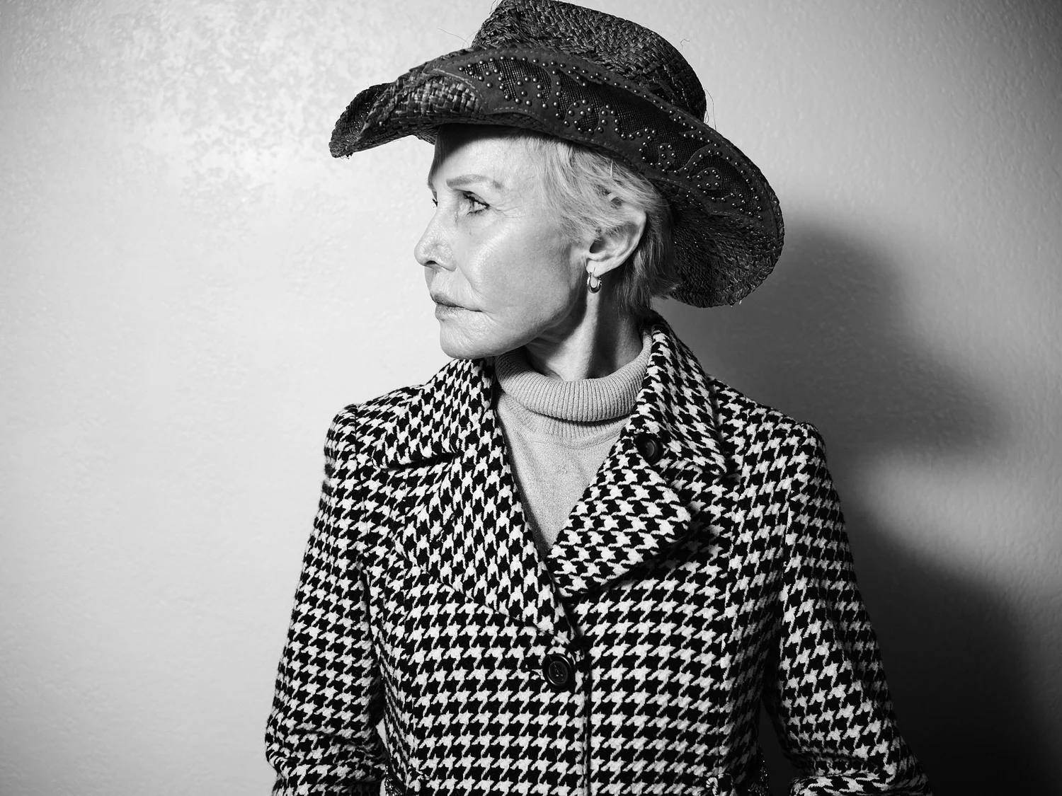 Actor in a cowboy hat and houndstooth coat, looking away, black and white