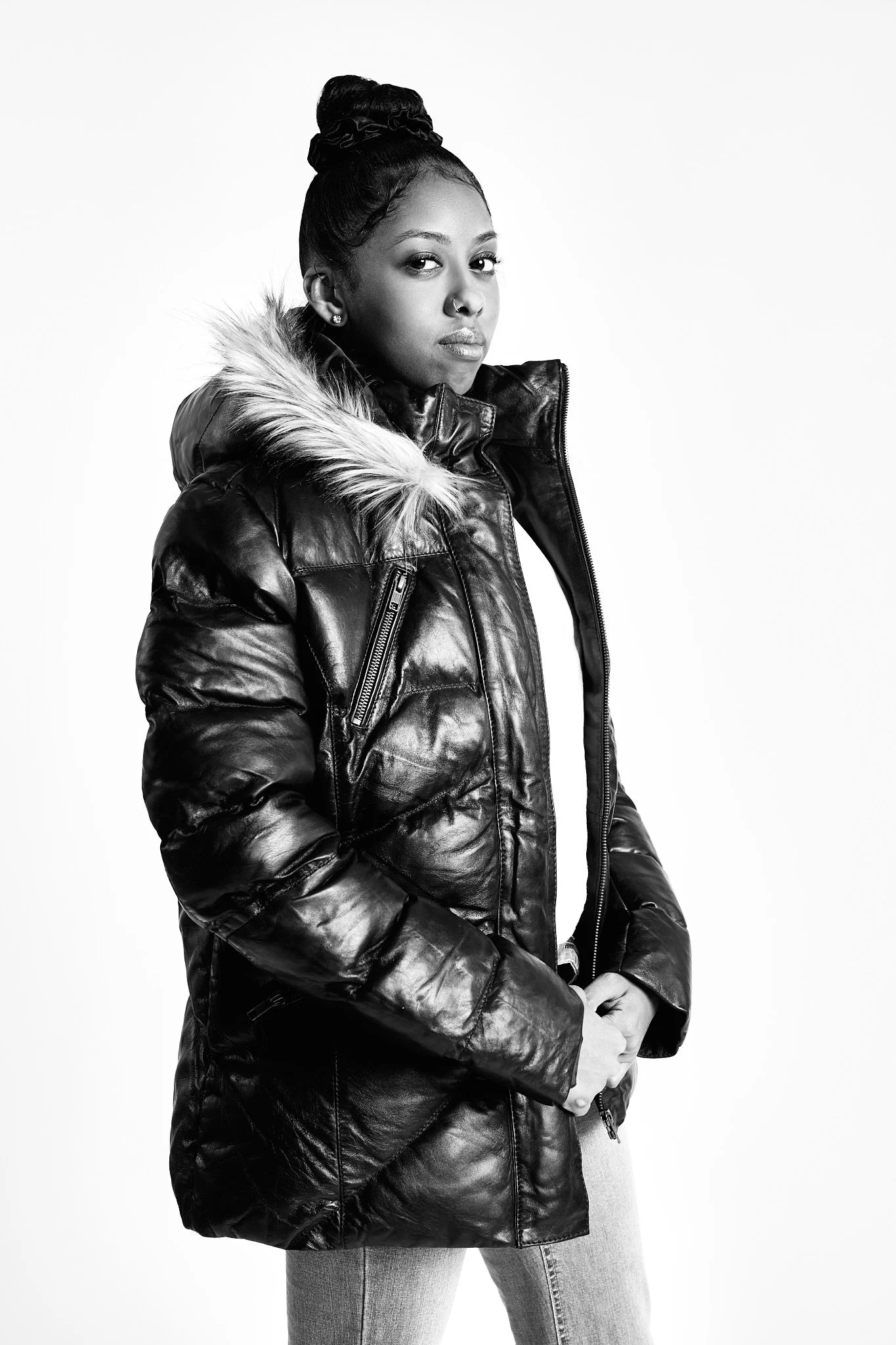A model in a fur-hooded puffer jacket for FAD Closet, on a white studio background, black and white