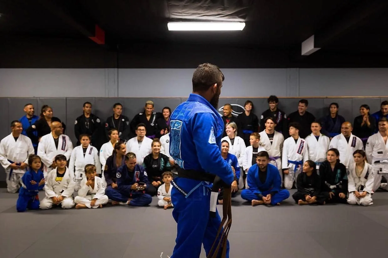 Javi addressing a seated open mat at JG Academy