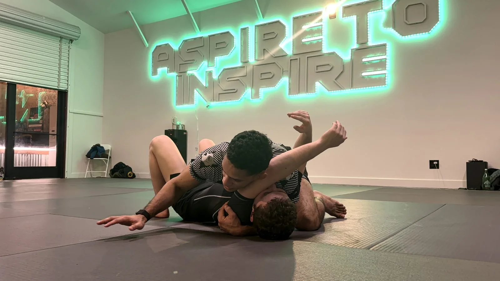 Two students rolling under the Aspire to Inspire sign