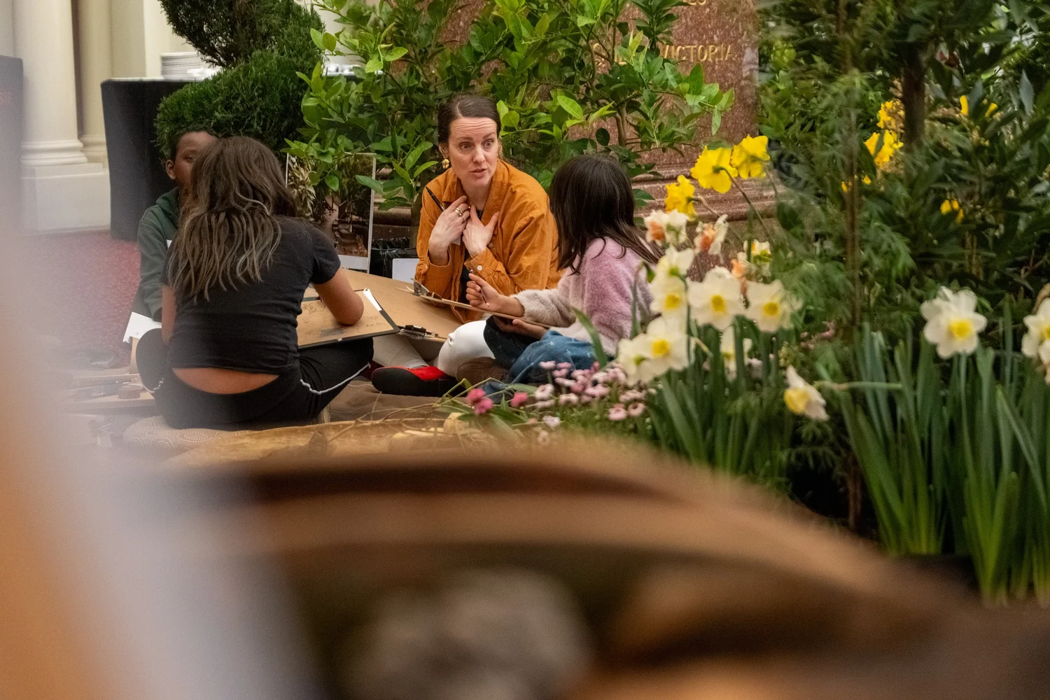 Visitors taking part in a drawing activity among the garden displays