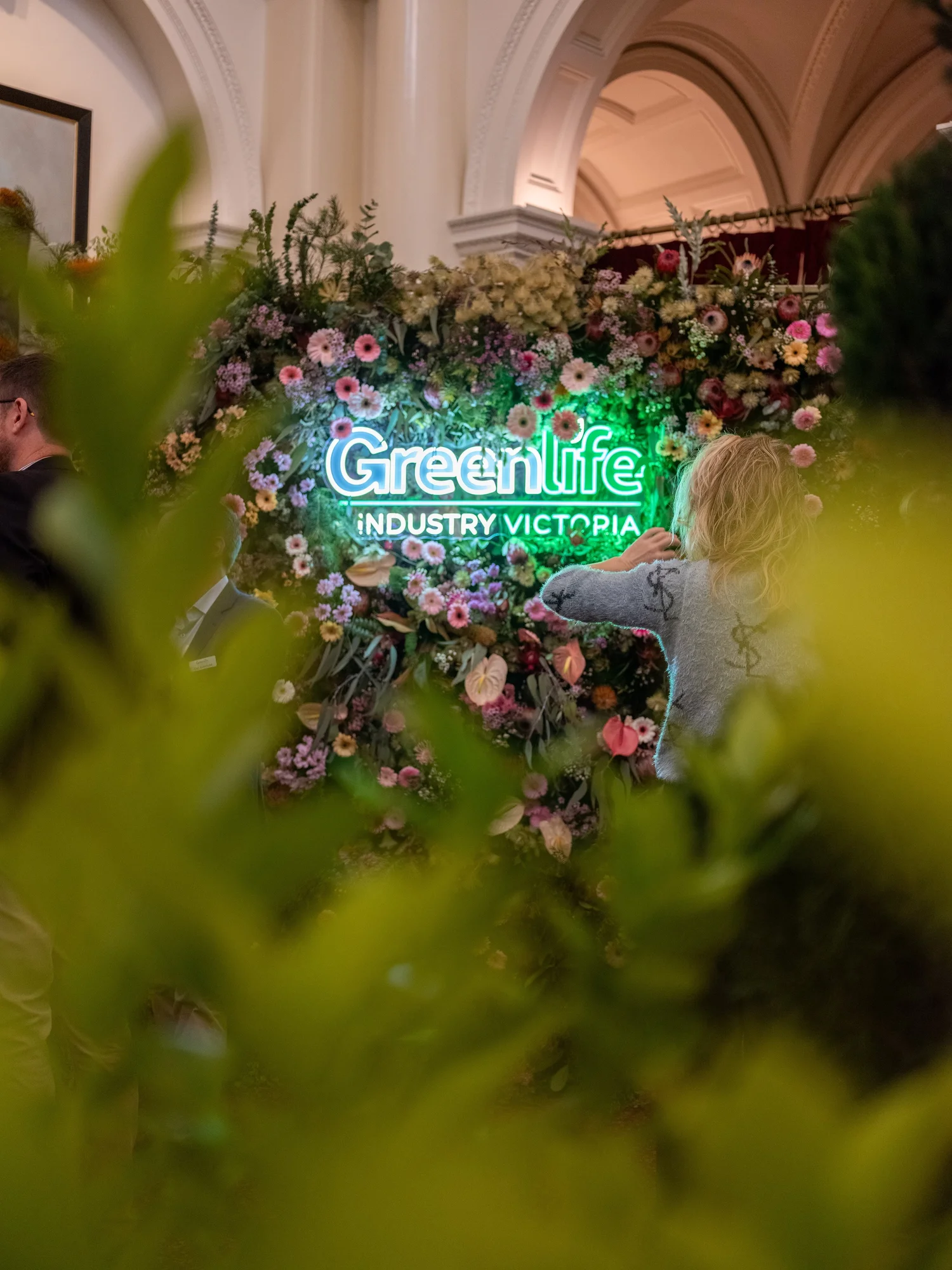 Illuminated Greenlife Industry Victoria sign surrounded by flowers