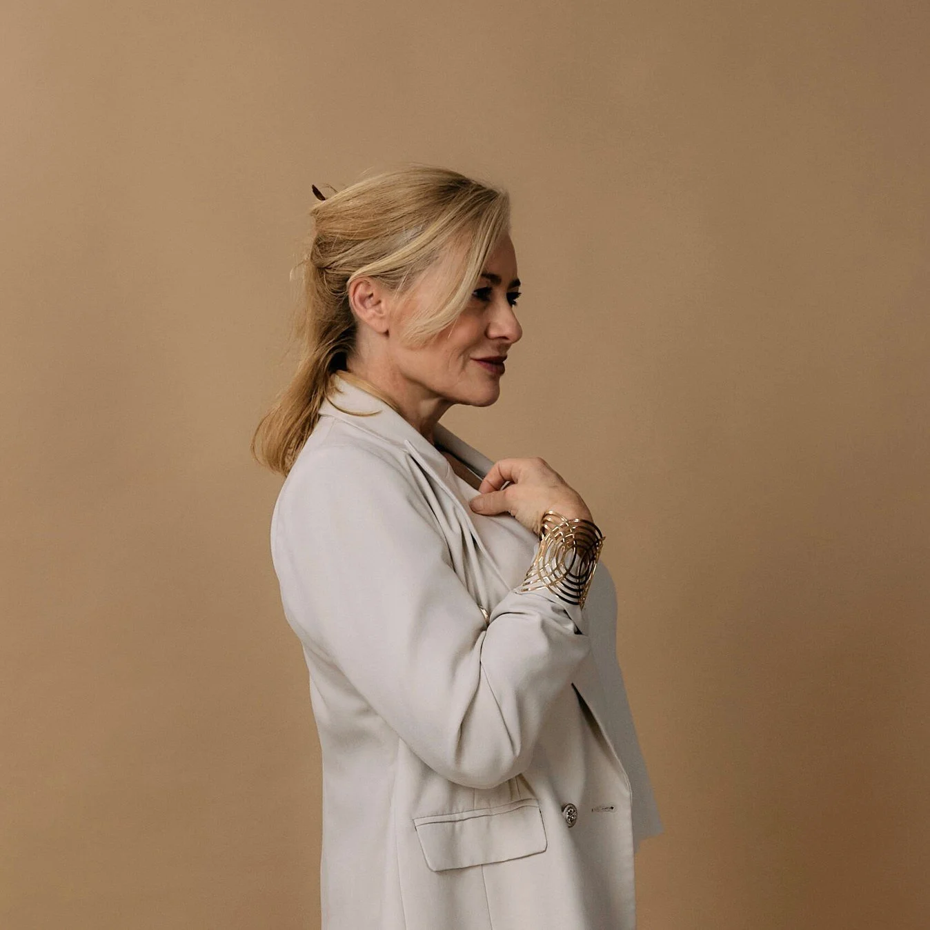Warm editorial portrait in a cream suit
