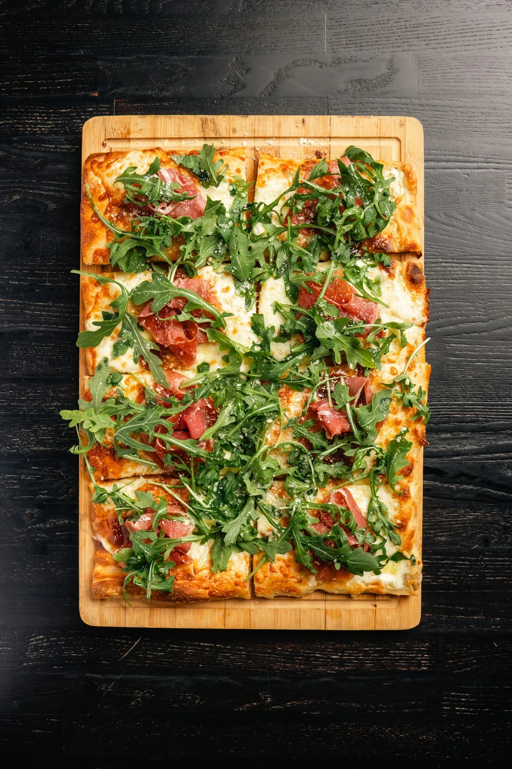 Florenza’s prosciutto and fig pizza, photographed overhead on a wooden board