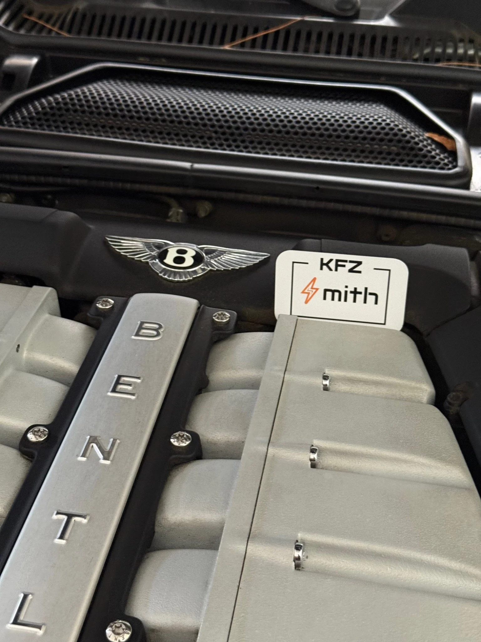 Gepflegter Bentley-Motorraum mit Bentley-Emblem und KFZ-Smith-Logo