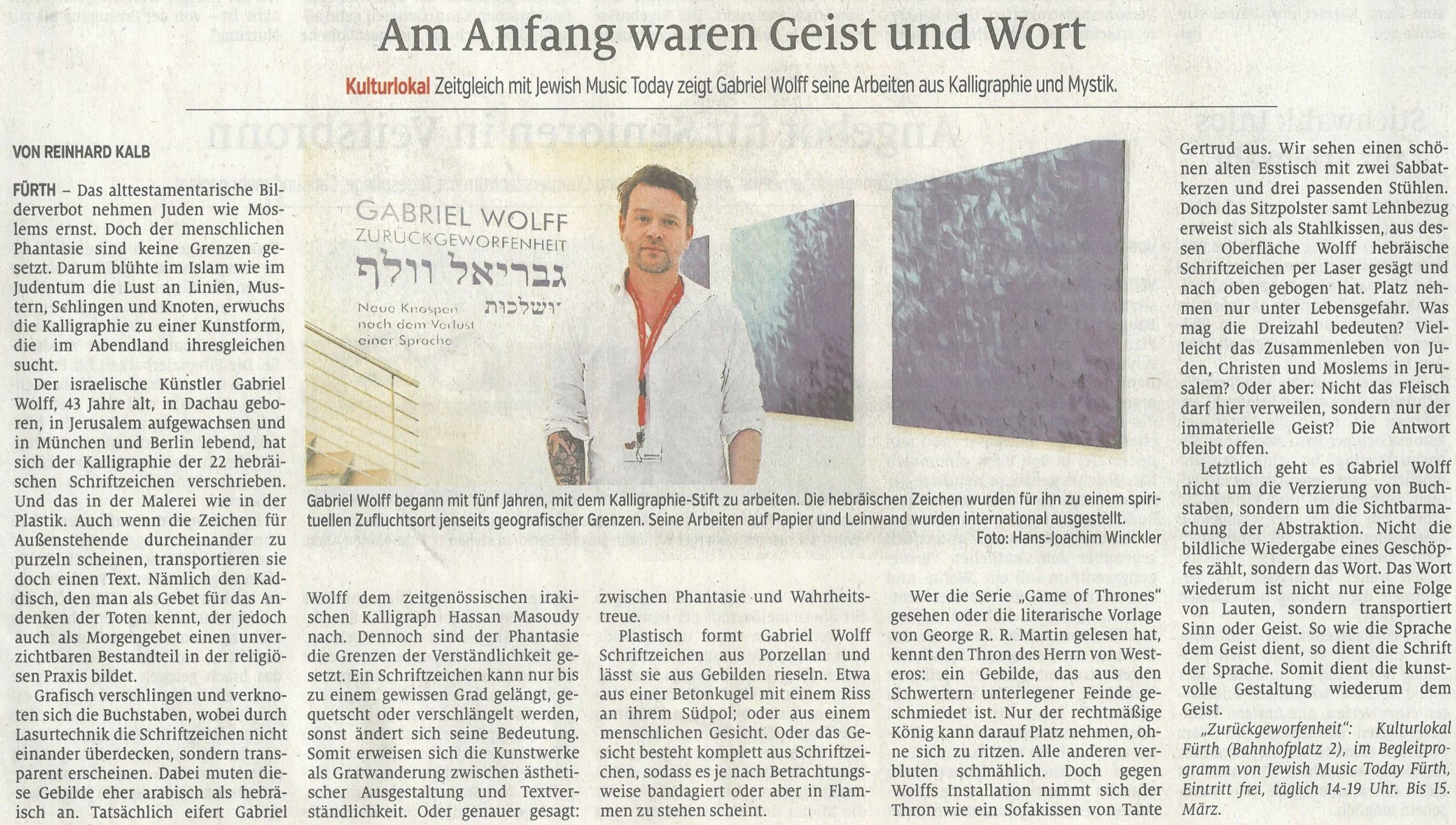 Scan of a newspaper page: the article “Am Anfang waren Geist und Wort” by Reinhard Kalb, with a photograph of Gabriel Wolff in front of the exhibition title wall.