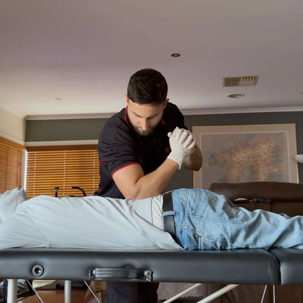 Power Physio physiotherapist giving hands-on treatment on a portable table at home