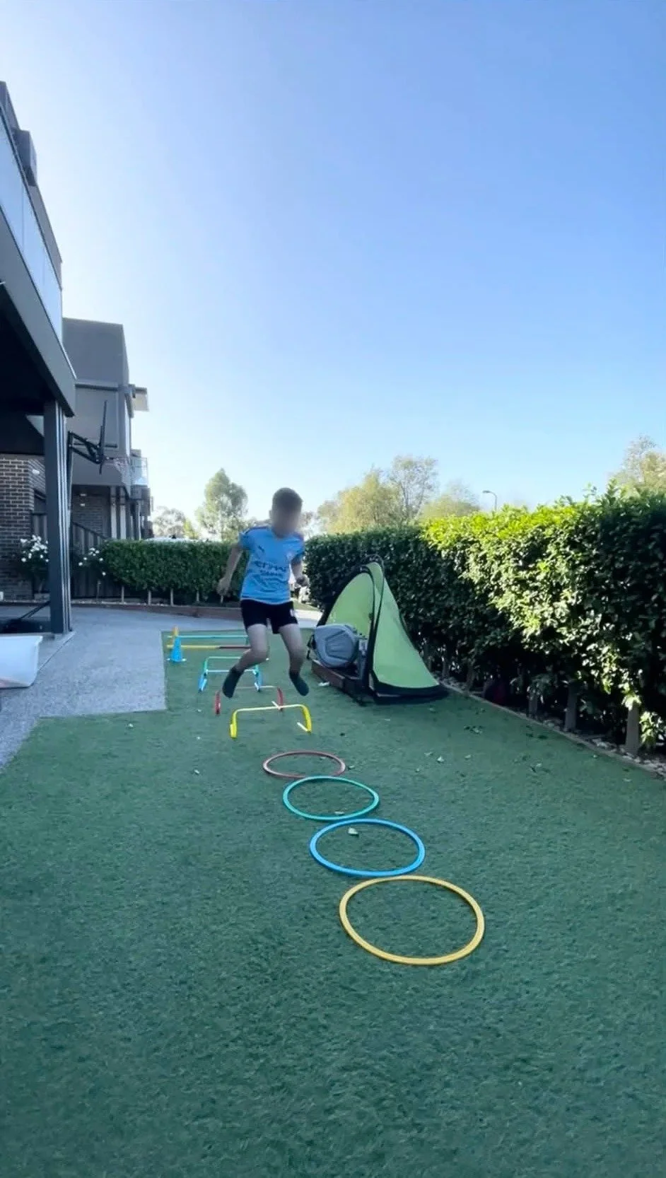 Child doing an agility exercise in a backyard