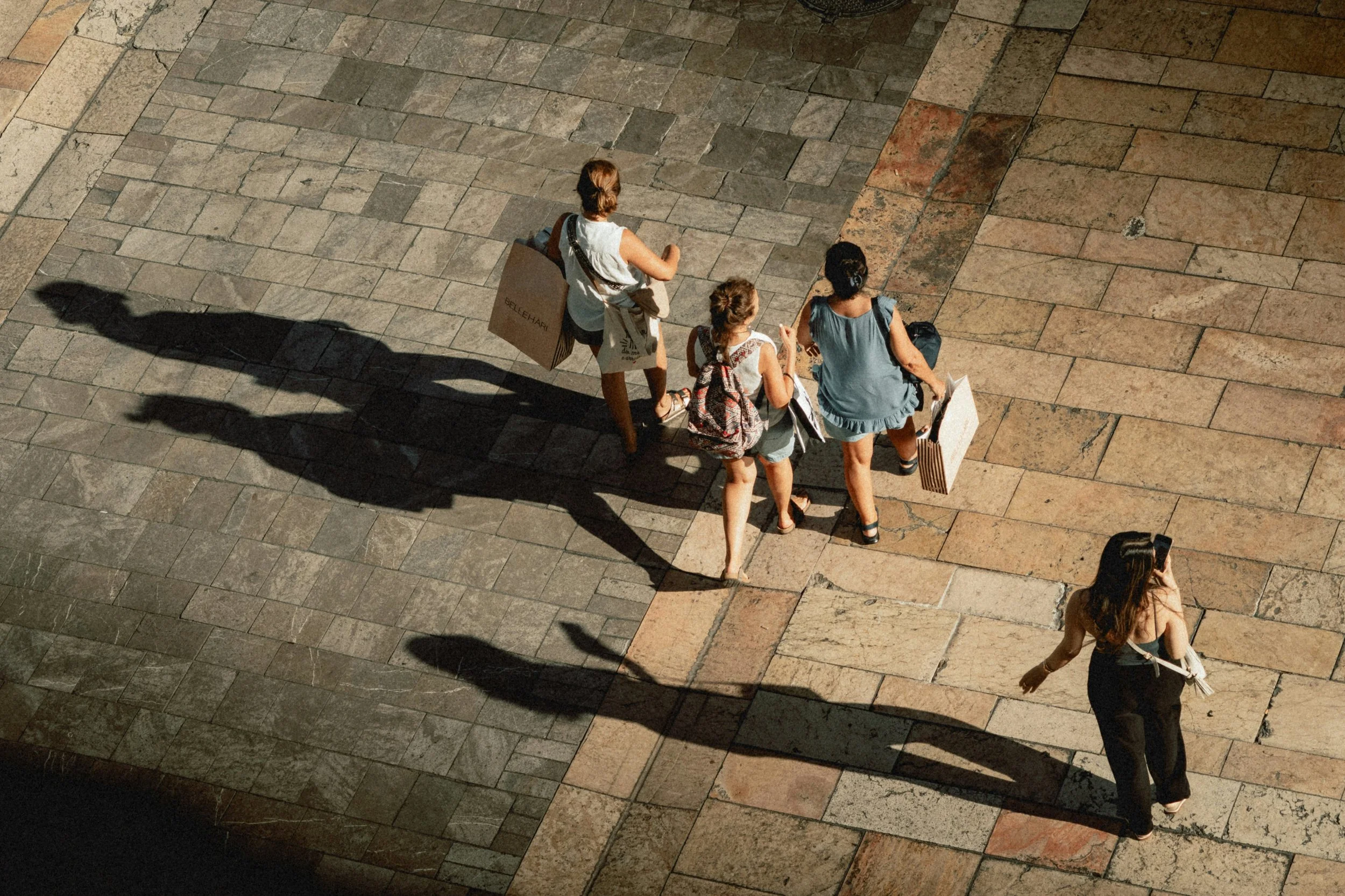 Women friends exploring a sun-drenched European street together
