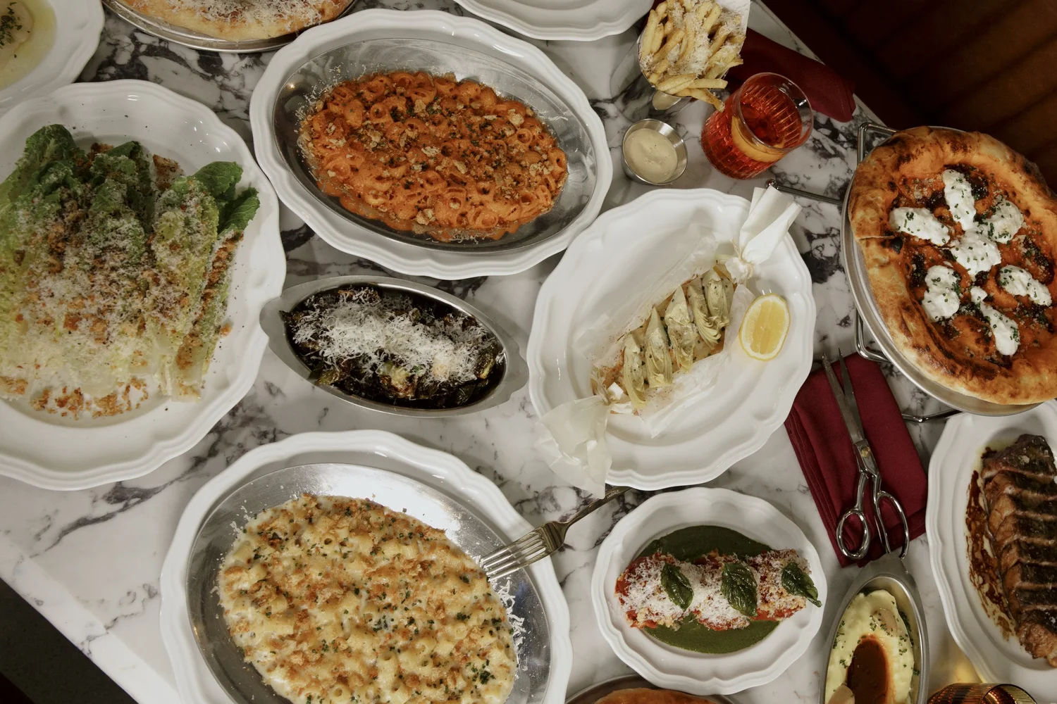 An overhead Salina spread of vodka rigatoni, Caesar, roasted brussels sprouts, eggplant parmesan and pizza