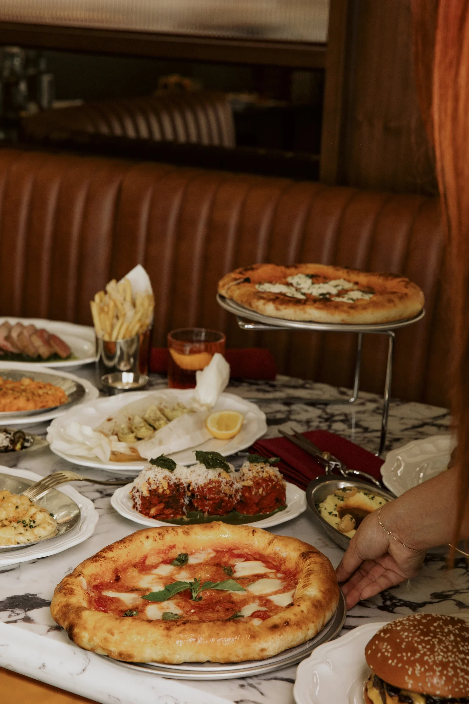 A margherita from Salina's open-flame oven with dishes across the marble table