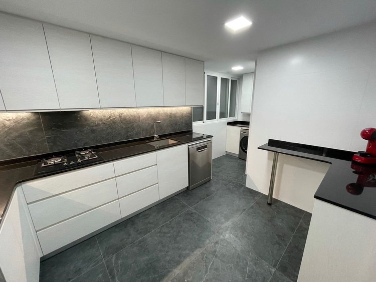 Cocina blanca con encimera negra y pavimento gris pizarra