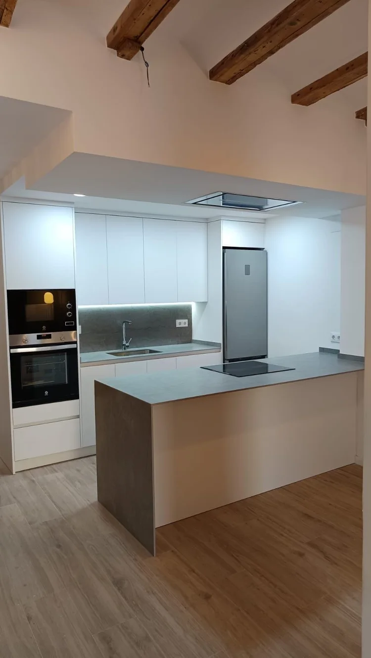 Cocina con península gris y techo con vigas de madera