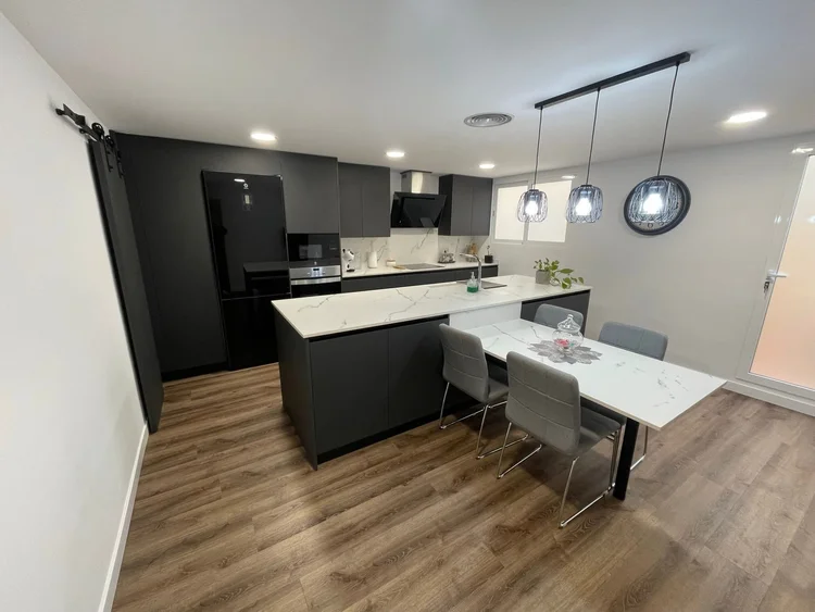 Cocina antracita con isla blanca y comedor