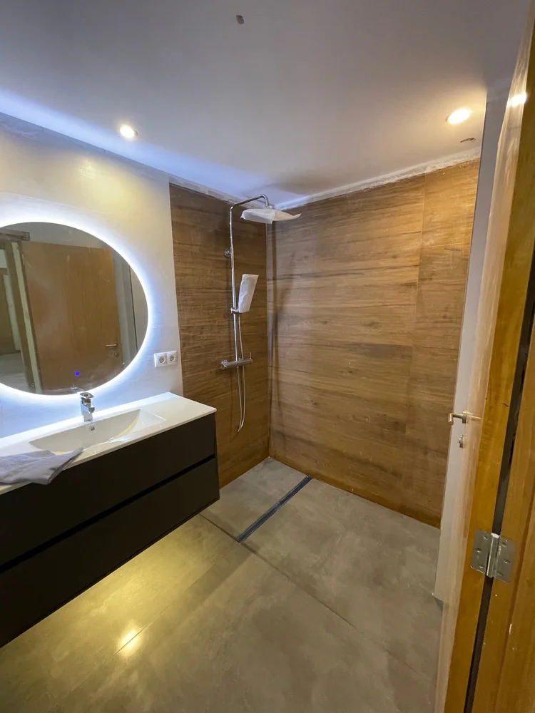 Ducha a ras de suelo con revestimiento porcelánico efecto madera