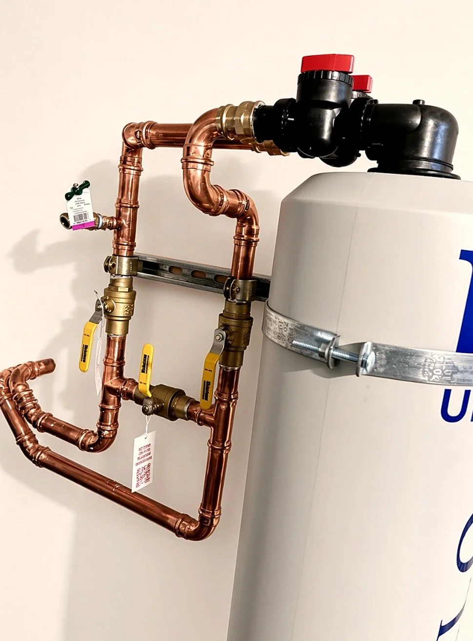 Soldered copper water line manifold feeding a whole-house water treatment tank