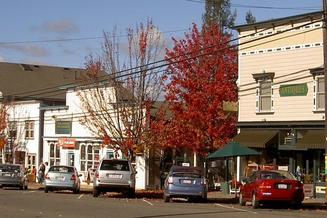Historic false-front storefronts and fall trees along Graton Road in downtown Graton