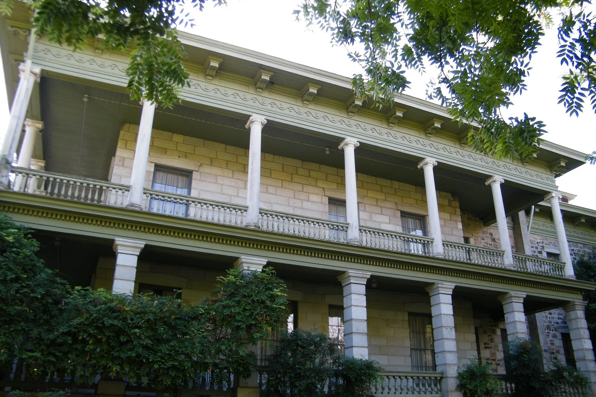 Columned two-story veranda of historic Temelec Hall framed by trees