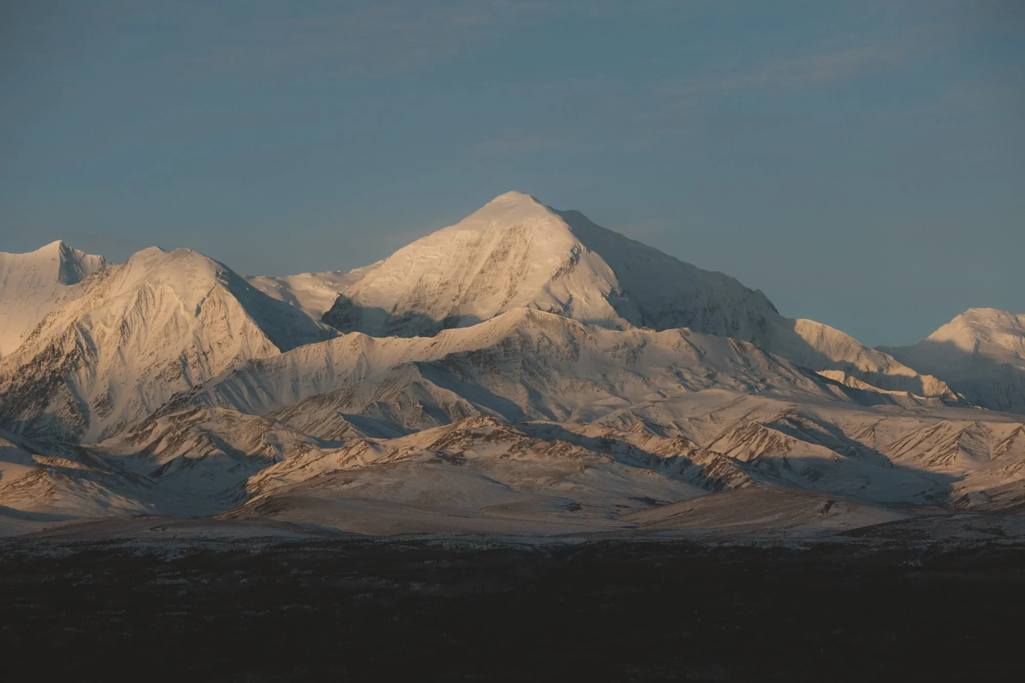 Snow-covered mountain peaks catching the last warm light of the day.