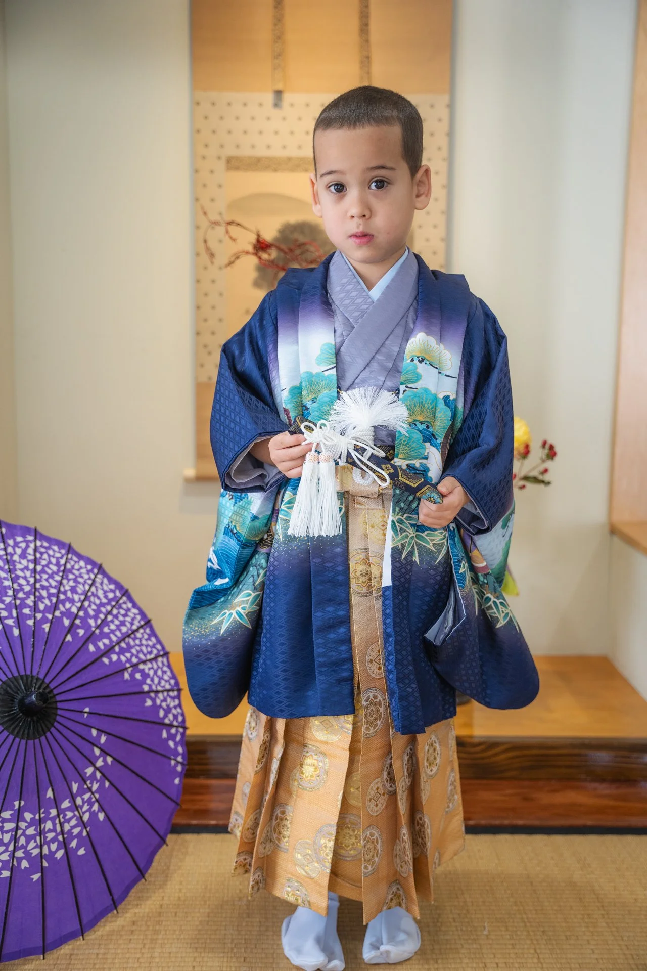 Child in a blue kimono and hakama standing in a Japanese-style room