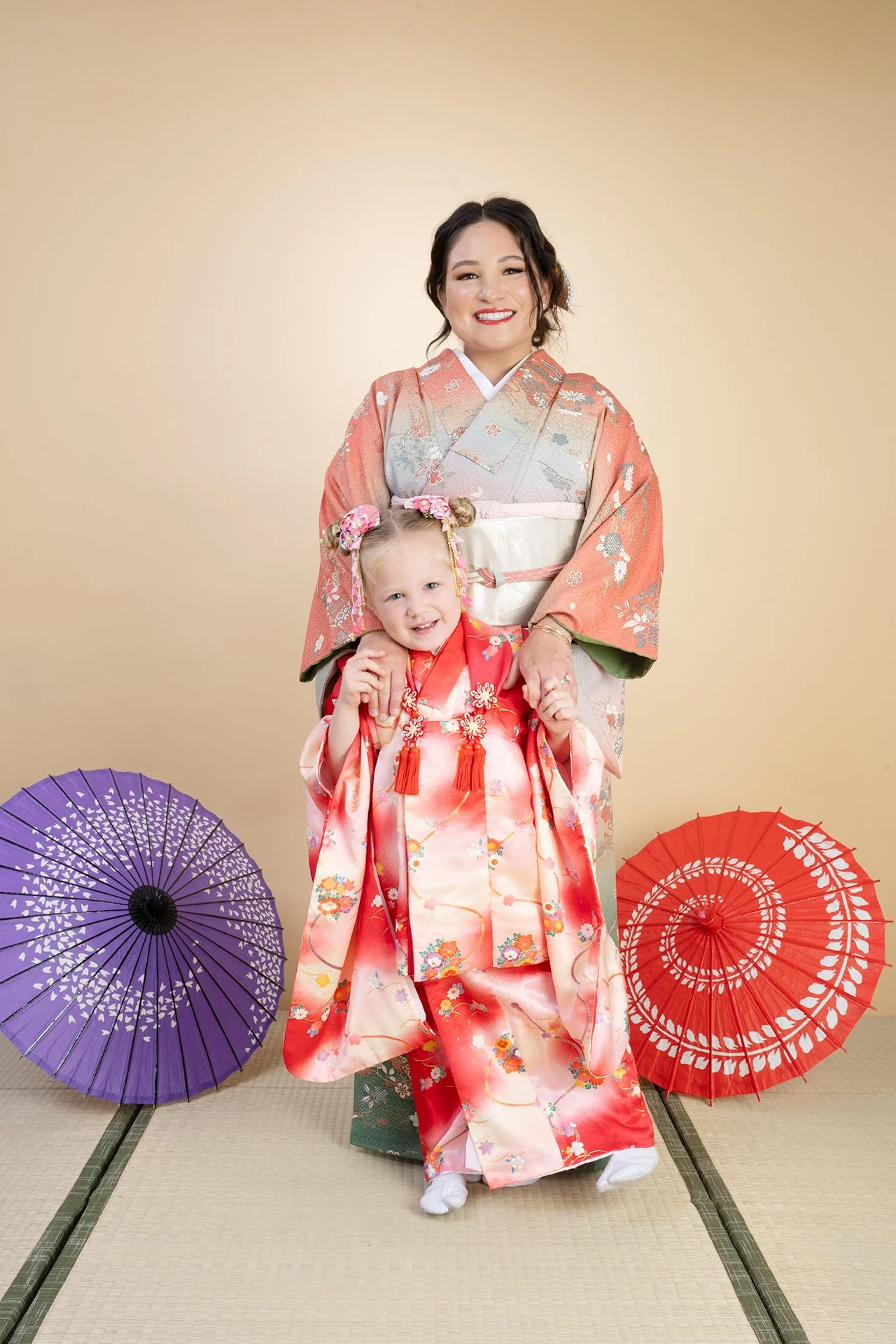 Woman and child in peach and coral kimono posing together