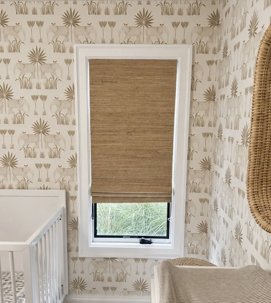 Natural woven wood shade fitted inside a white-framed nursery window