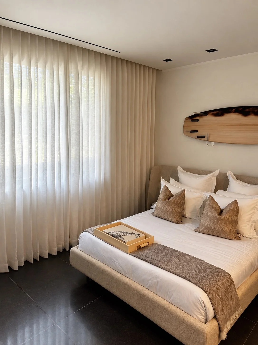Full-height neutral drapery along a bedroom window wall
