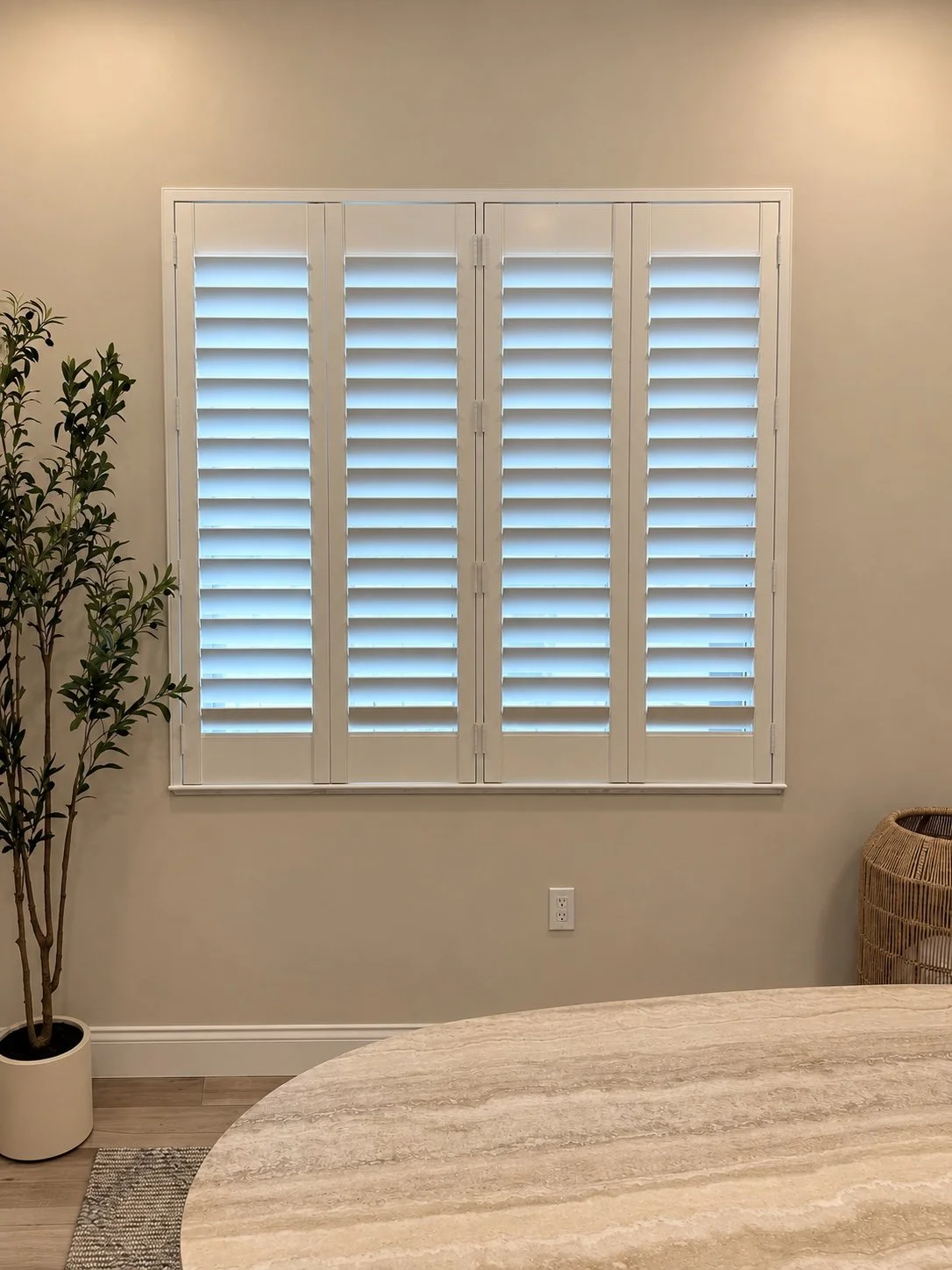 White plantation shutters fitted to a bedroom window