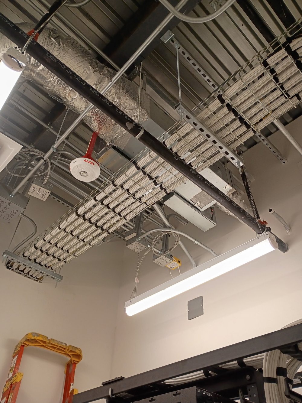 Overhead wire-basket cable tray with bundled ACS cabling runs at Intuitive Machines