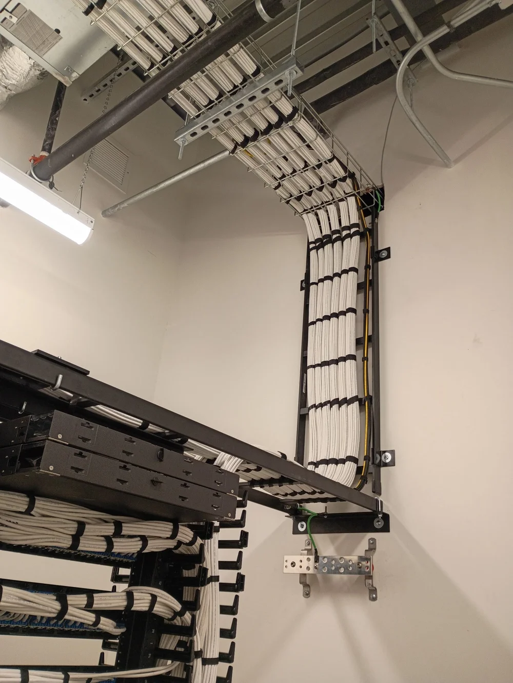 ACS-installed Cat6A bundle dressed down a wall-mounted ladder rack to the equipment rack at Intuitive Machines