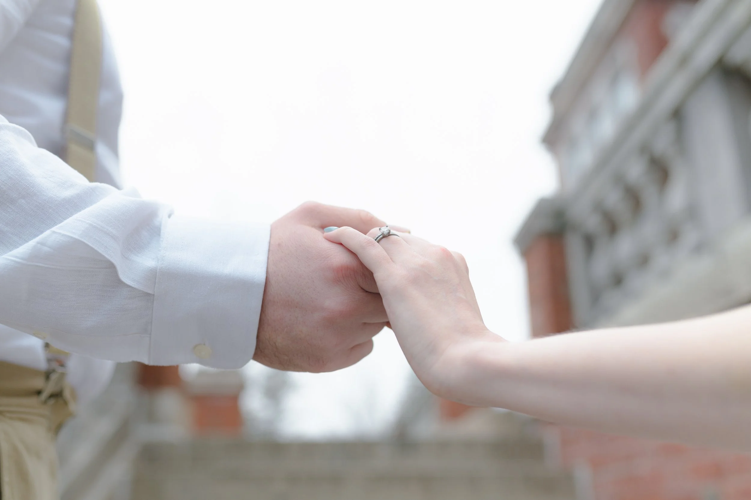 A couple's hands find each other as they climb stairs.