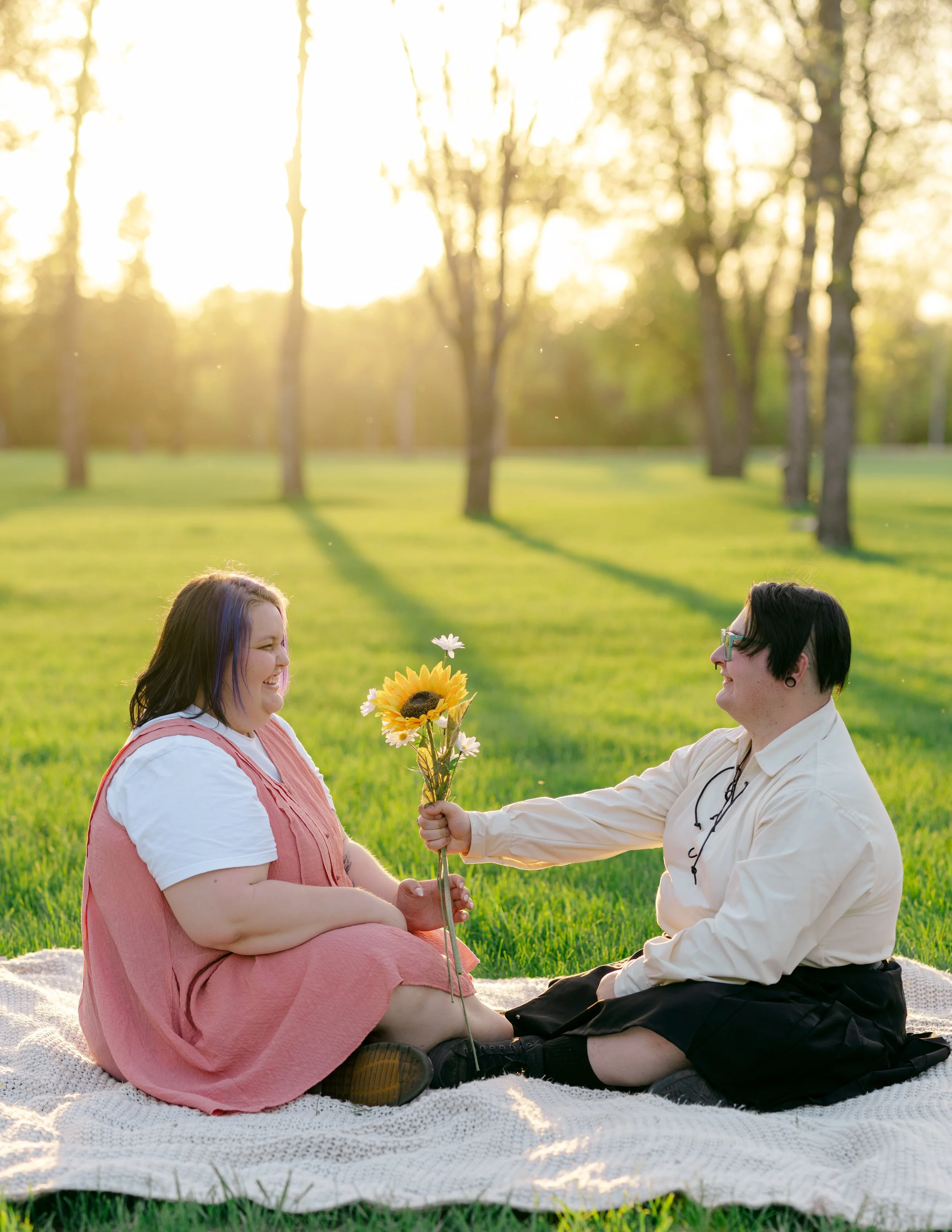 A partner gifts a sunflower boquet to their lover while the sunlight glows around them.