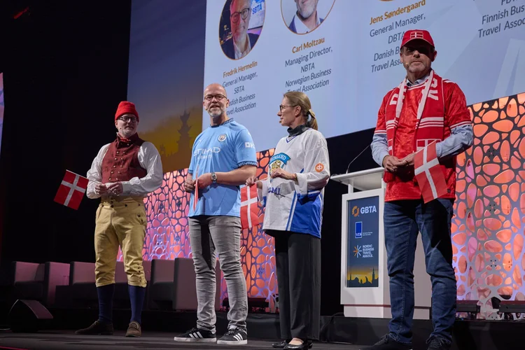 Fredrik, Carl, Sari og Jens står på scenen i København med det danske flagget i hånden