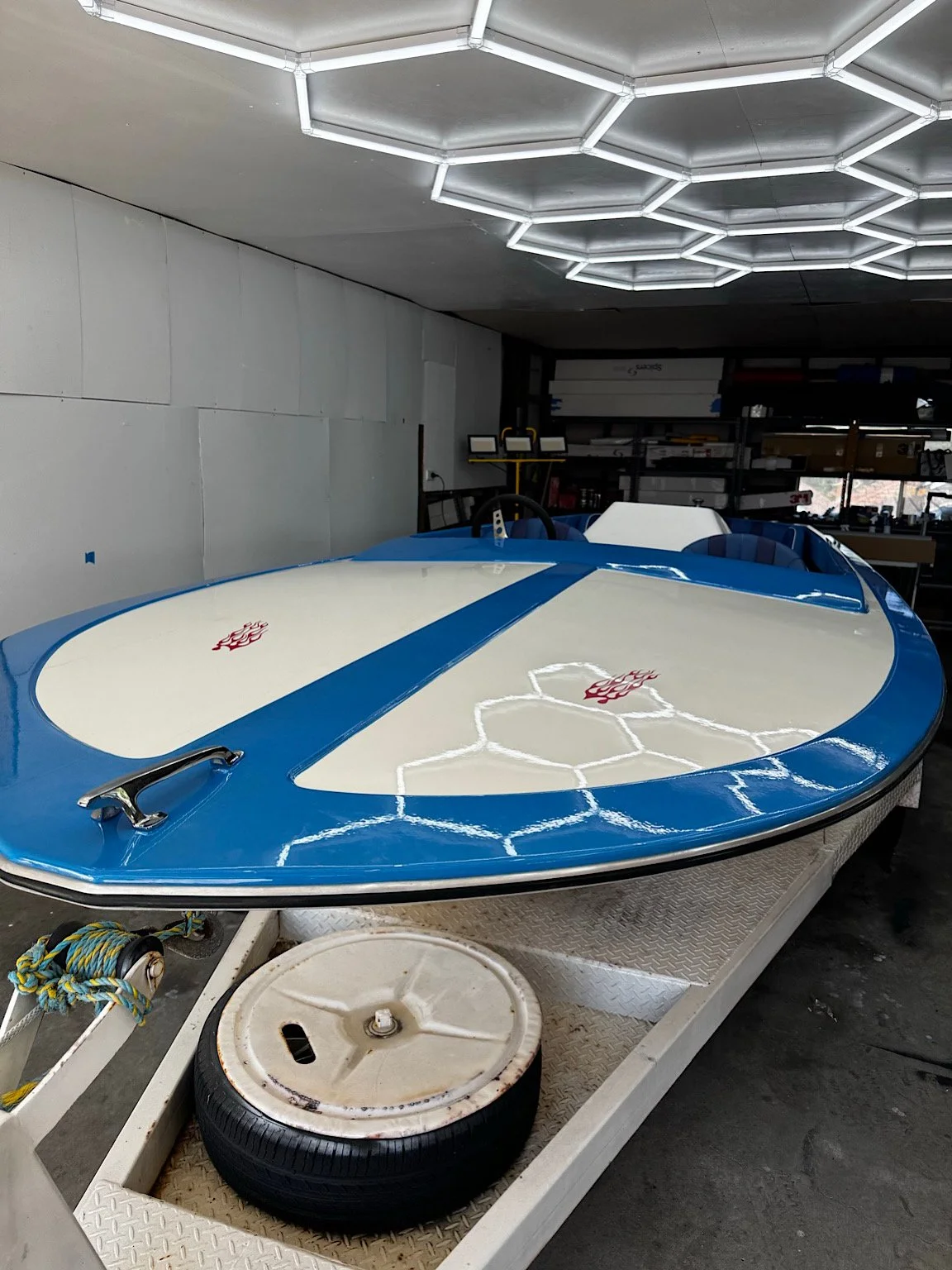 Angled front view of the blue-and-white boat showing its glossy top section after paint correction and PPF installation.