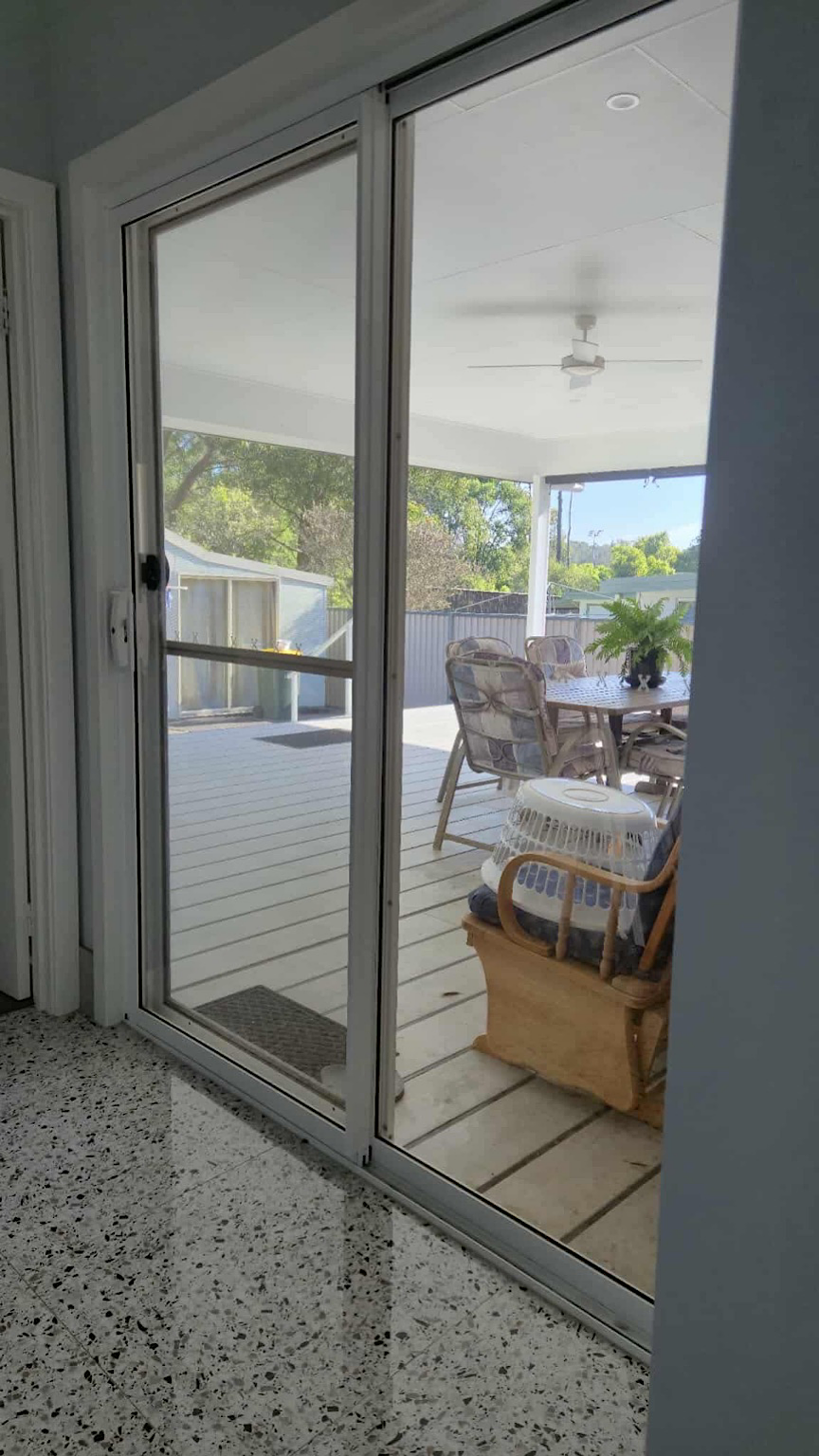Main house sliding door before window tint showing glare and sunlight entering interior Central Coast NSW