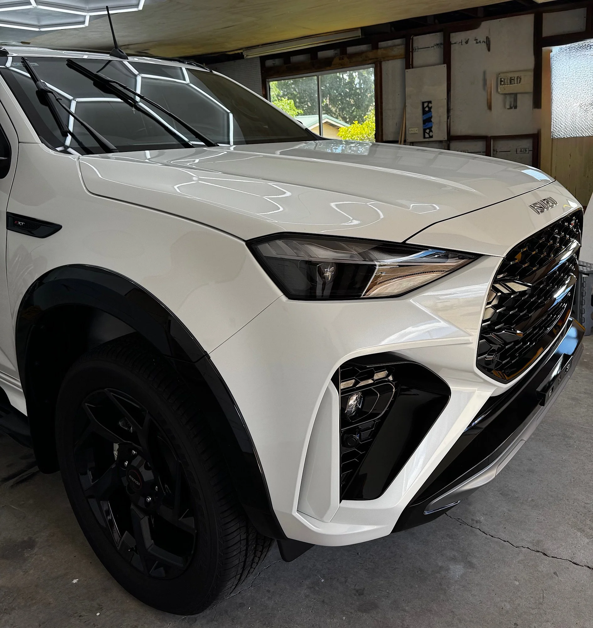 Close-up of the bonnet, headlight and grille on a white 2026 Isuzu MU-X after Gtechniq CSU and EXOv5 ceramic coating