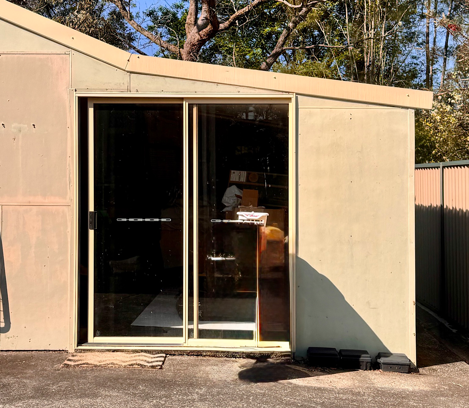 Shed sliding door before window tint installation showing clear glass and full sun exposure Central Coast NSW