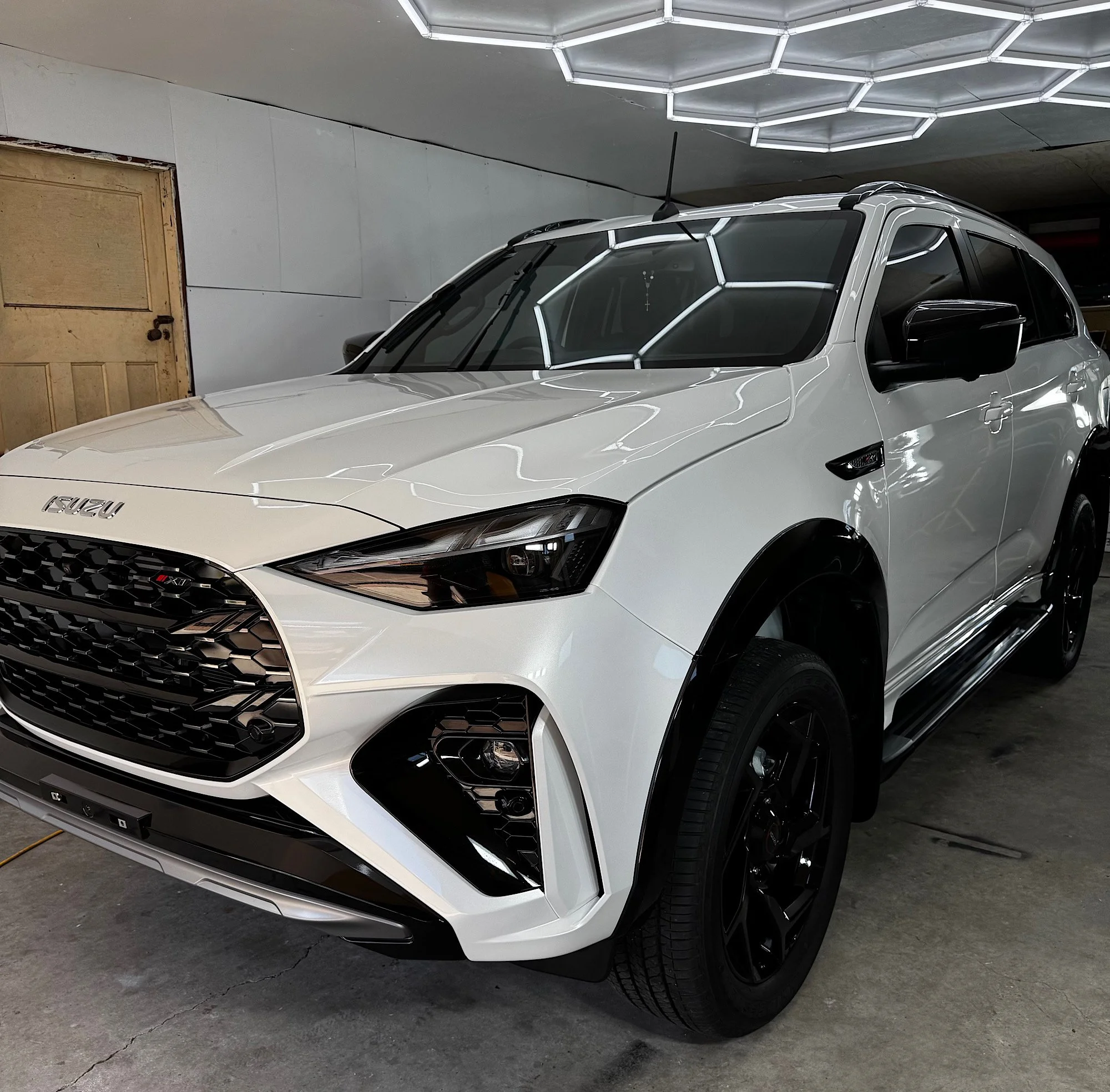 Front three-quarter view of a white 2026 Isuzu MU-X after CSU ceramic coating and full window tinting at our Wyong studio